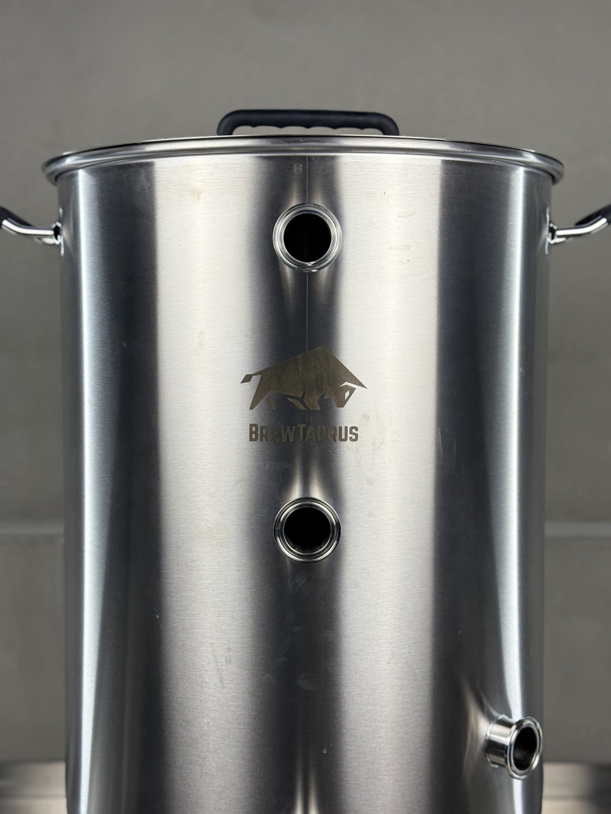 K80 Boil Kettle — close-up of the 1.5" Tri-Clamp front ports, the whirlpool port and the etched BrewTaurus logo
